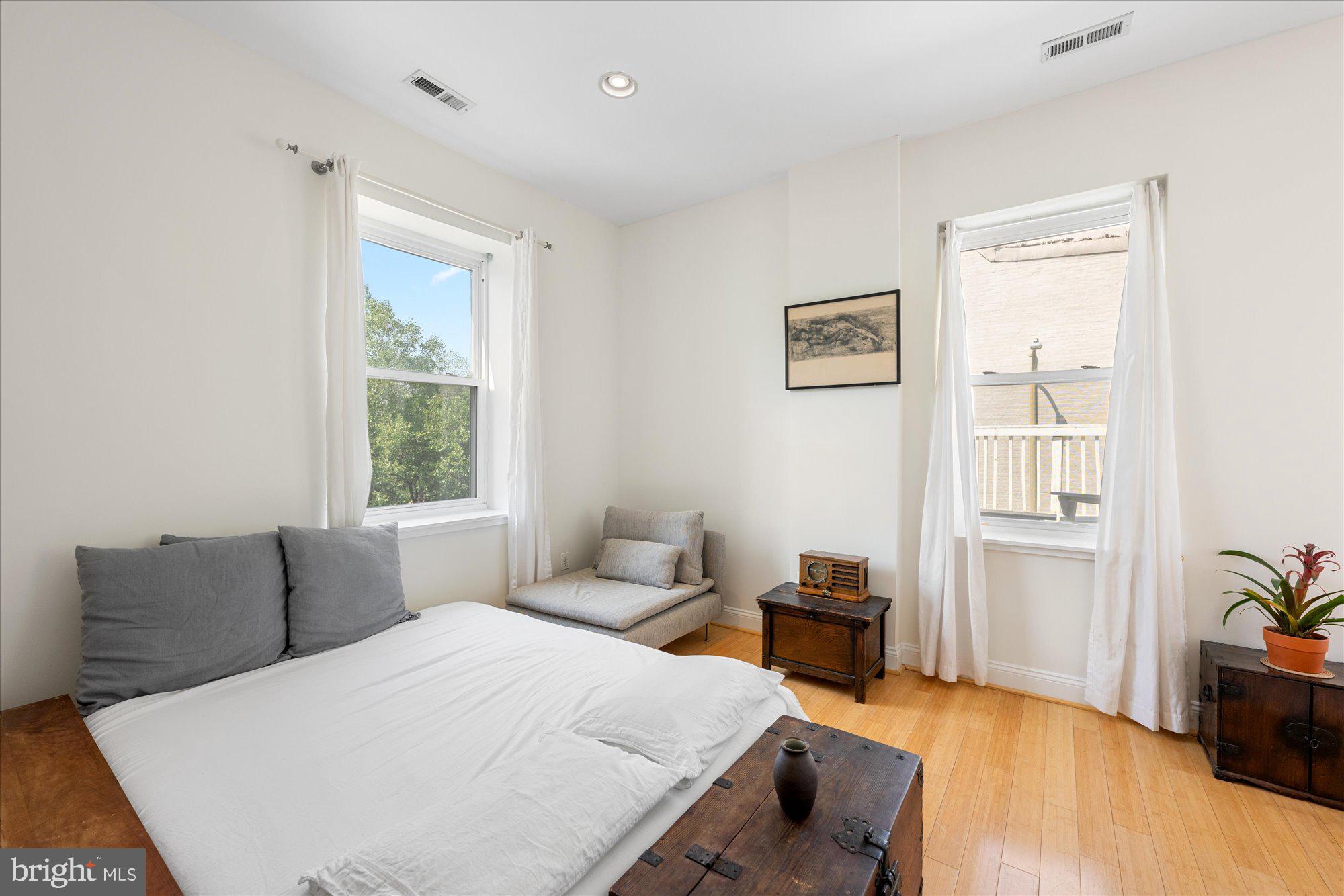 1124 E Street Northeast, Unit A Washington, DC 20002 - Photo 7 of 10 a bedroom with a bed and wooden floor