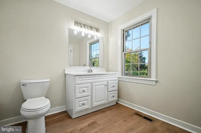 a bathroom with a toilet a sink a vanity and mirror