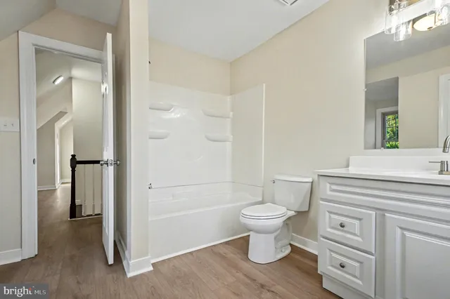 a view of empty room with wooden floor and fireplace