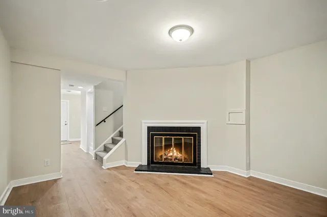 an empty room with wooden floor and a bathroom