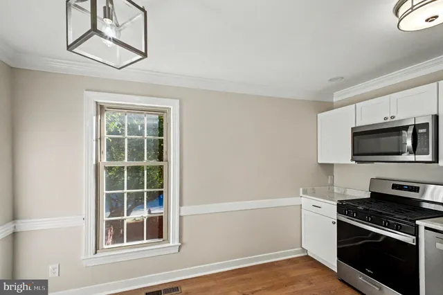 a kitchen with stainless steel appliances a stove microwave and sink
