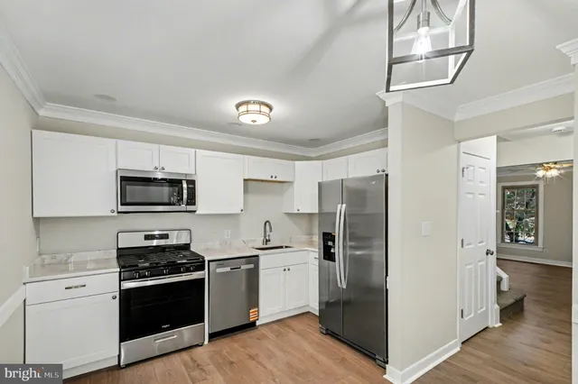 a kitchen with stainless steel appliances granite countertop a refrigerator a stove top oven a sink and dishwasher