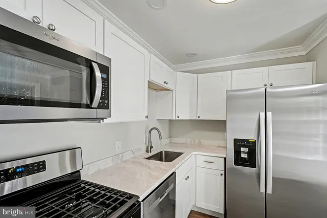 a kitchen with stainless steel appliances granite countertop a refrigerator and a stove top oven