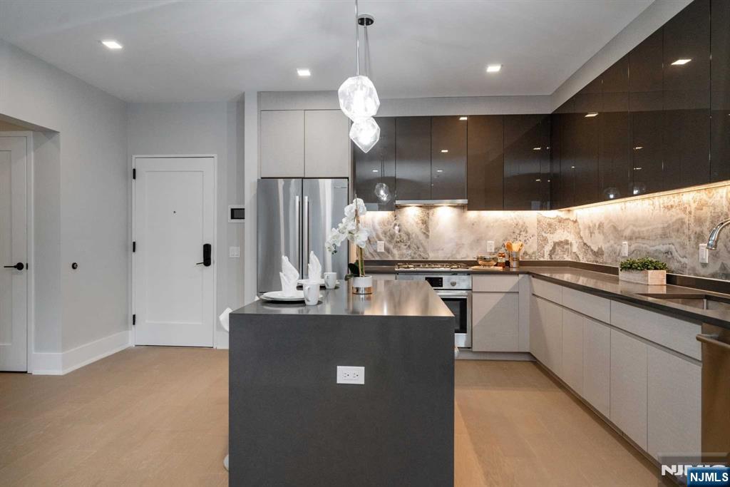 7101 River Road, Unit 304A North Bergen, NJ 07047 - Photo 5 of 24 a kitchen with kitchen island granite countertop a sink a counter top space appliances and cabinets