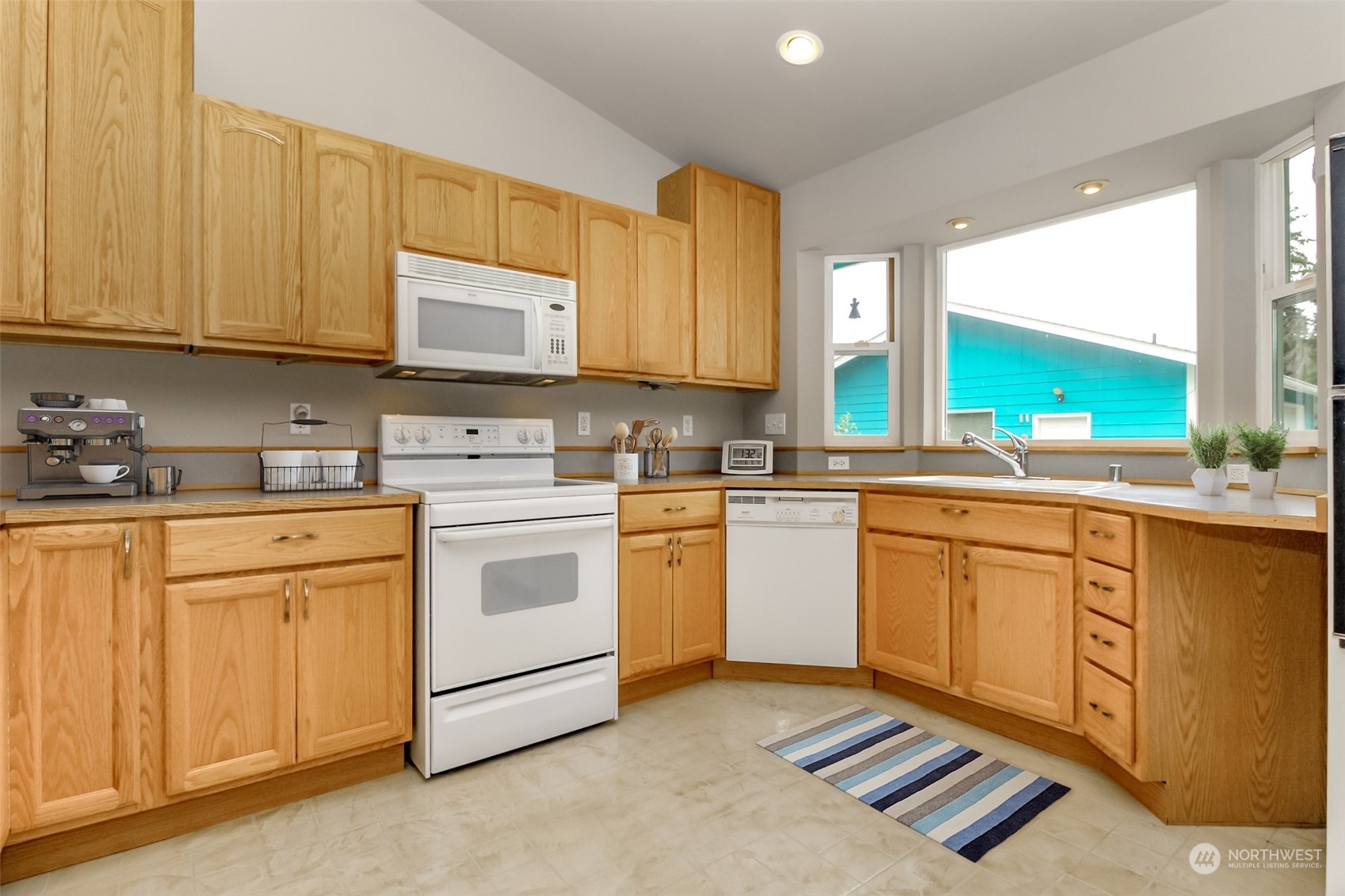 2401 Northeast 27th Street Renton, WA 98056 - Photo 10 of 24 a kitchen with stainless steel appliances granite countertop a stove a sink and a microwave