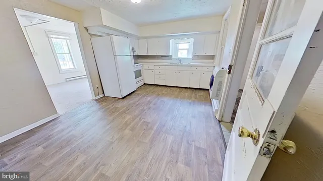 an empty room with wooden floor and a fireplace