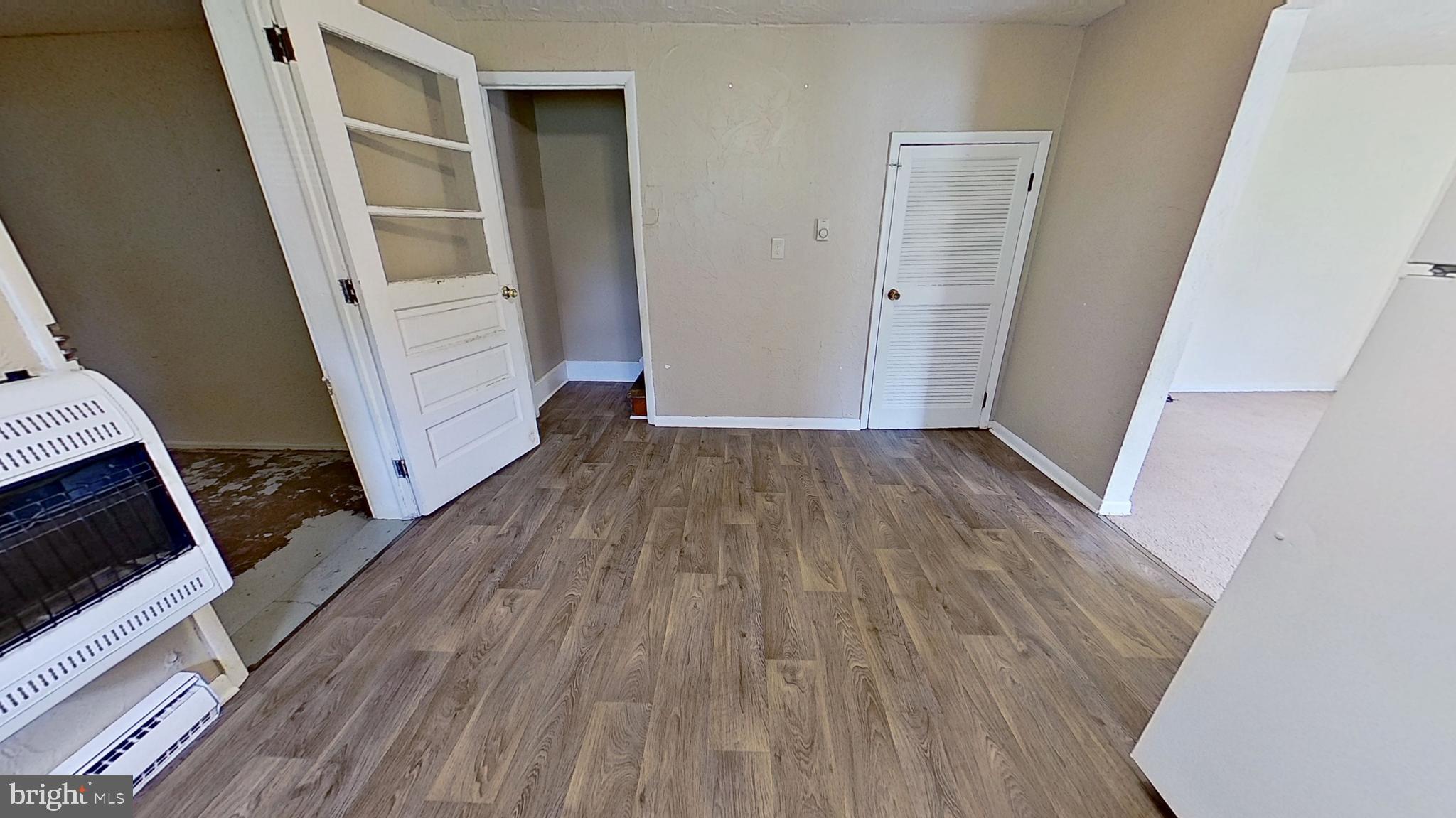 185 Burkholder Road Red Lion, PA 17356 - Photo 5 of 11 an empty room with wooden floor and a fireplace