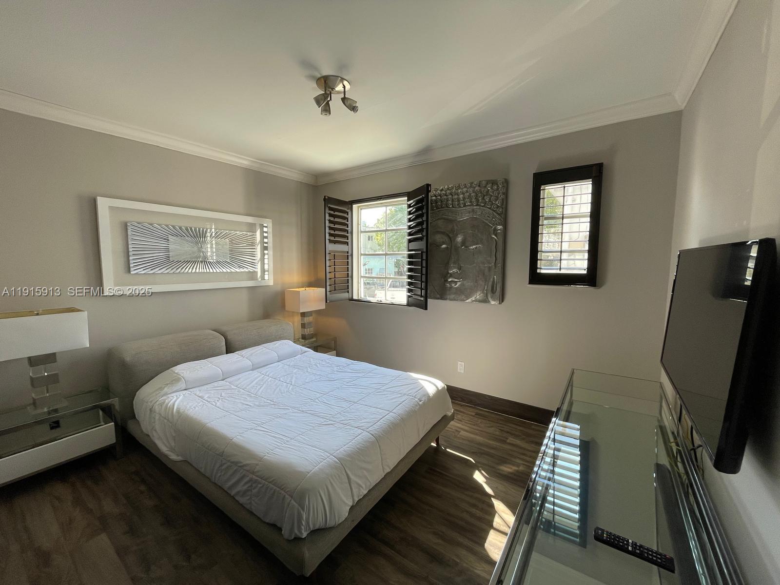 610 8th Street, Unit 101 Miami Beach, FL 33139 - Photo 13 of 17 a bedroom with a bed wooden floor and window