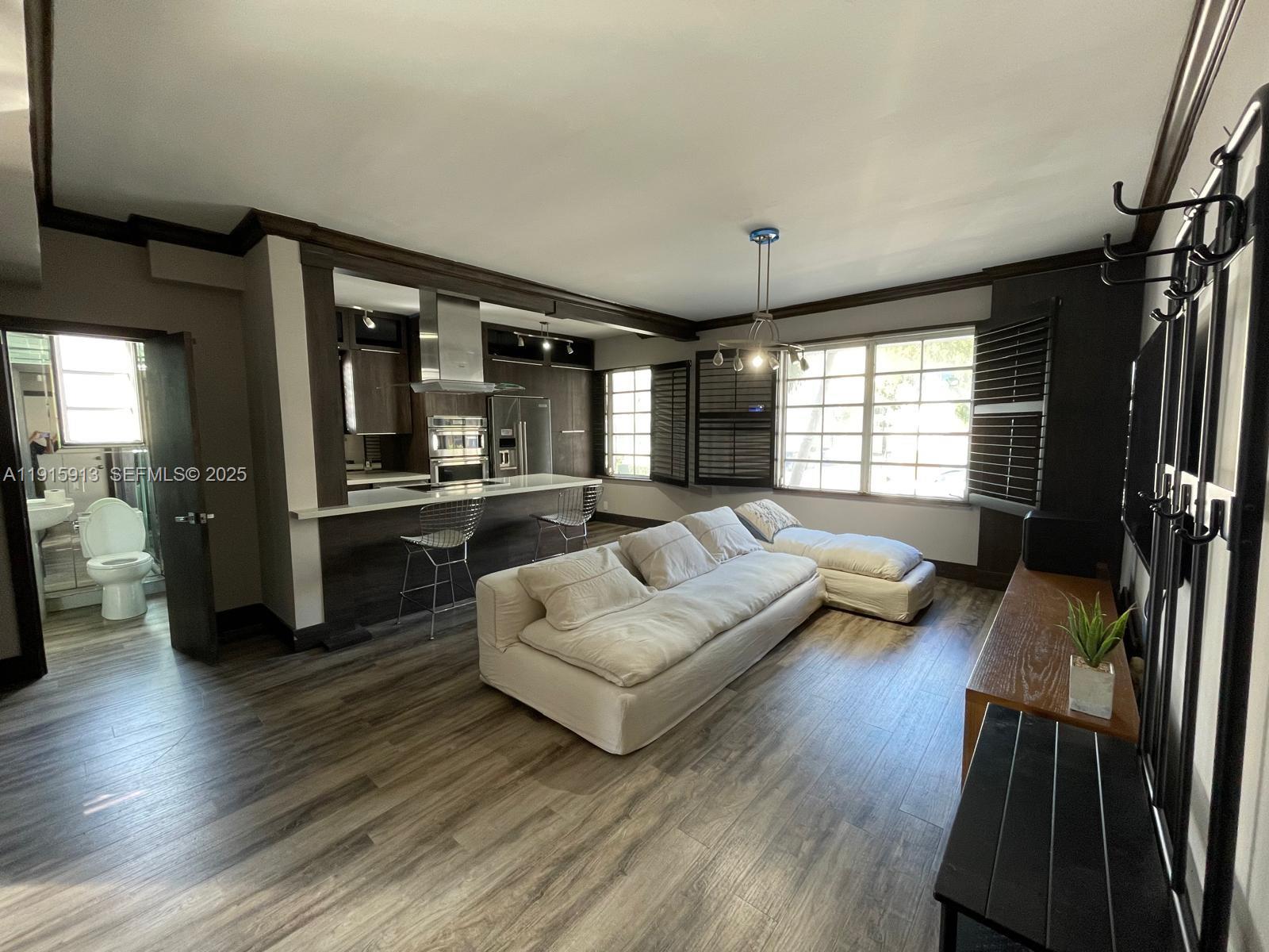610 8th Street, Unit 101 Miami Beach, FL 33139 - Photo 5 of 17 a living room with furniture and a large window