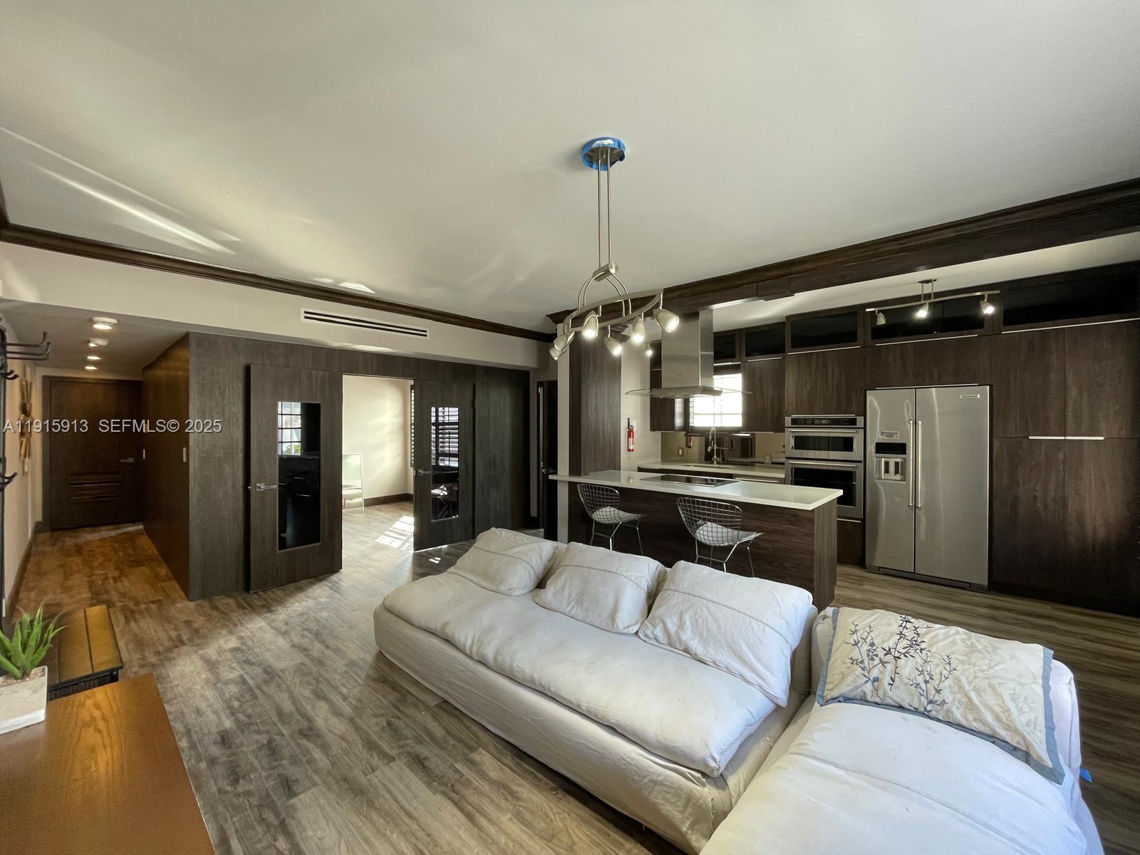 610 8th Street, Unit 101 Miami Beach, FL 33139 - Photo 6 of 17 a living room with furniture and a chandelier