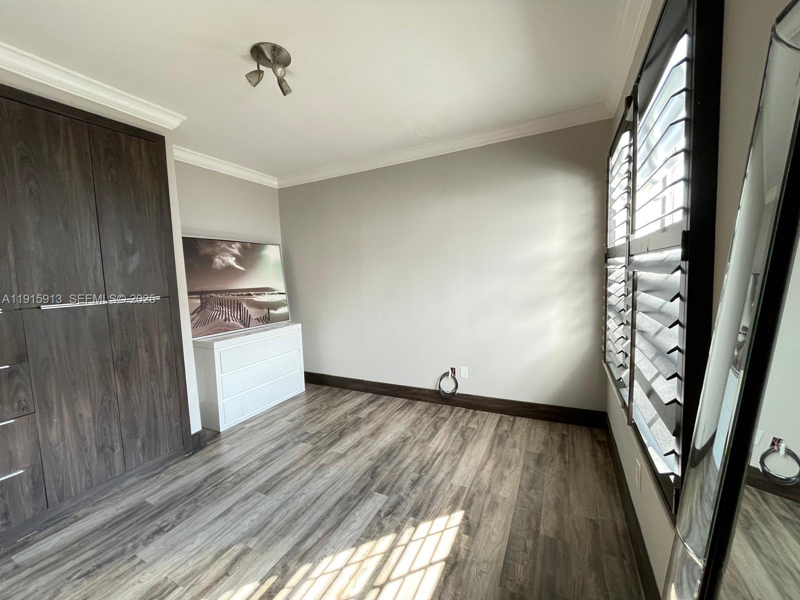 610 8th Street, Unit 101 Miami Beach, FL 33139 - Photo 9 of 17 a view of empty room with wooden floor and fan