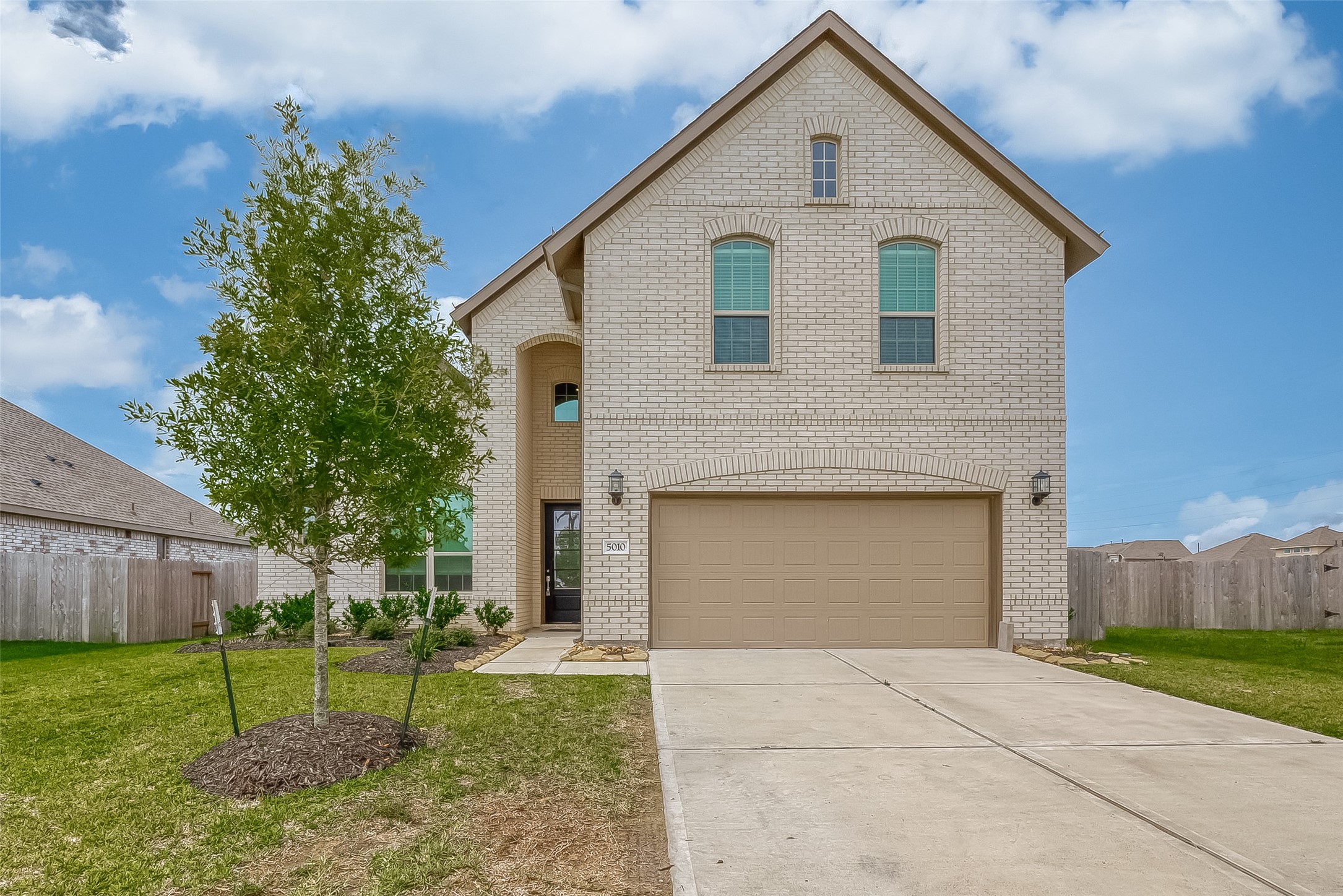Modern two-story home with two-car garage, front lawn and a driveway.