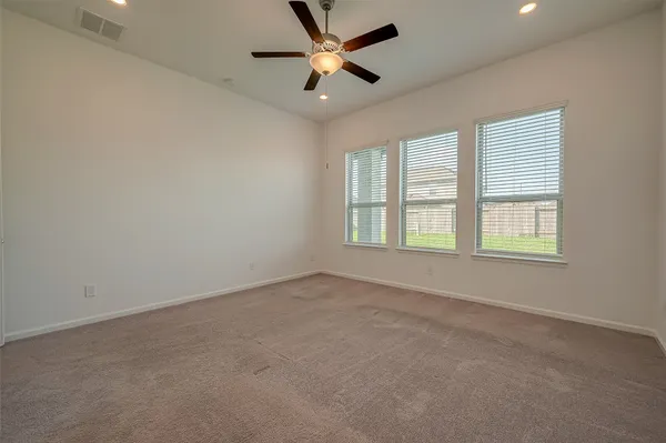 an empty room with a ceiling fan and a window