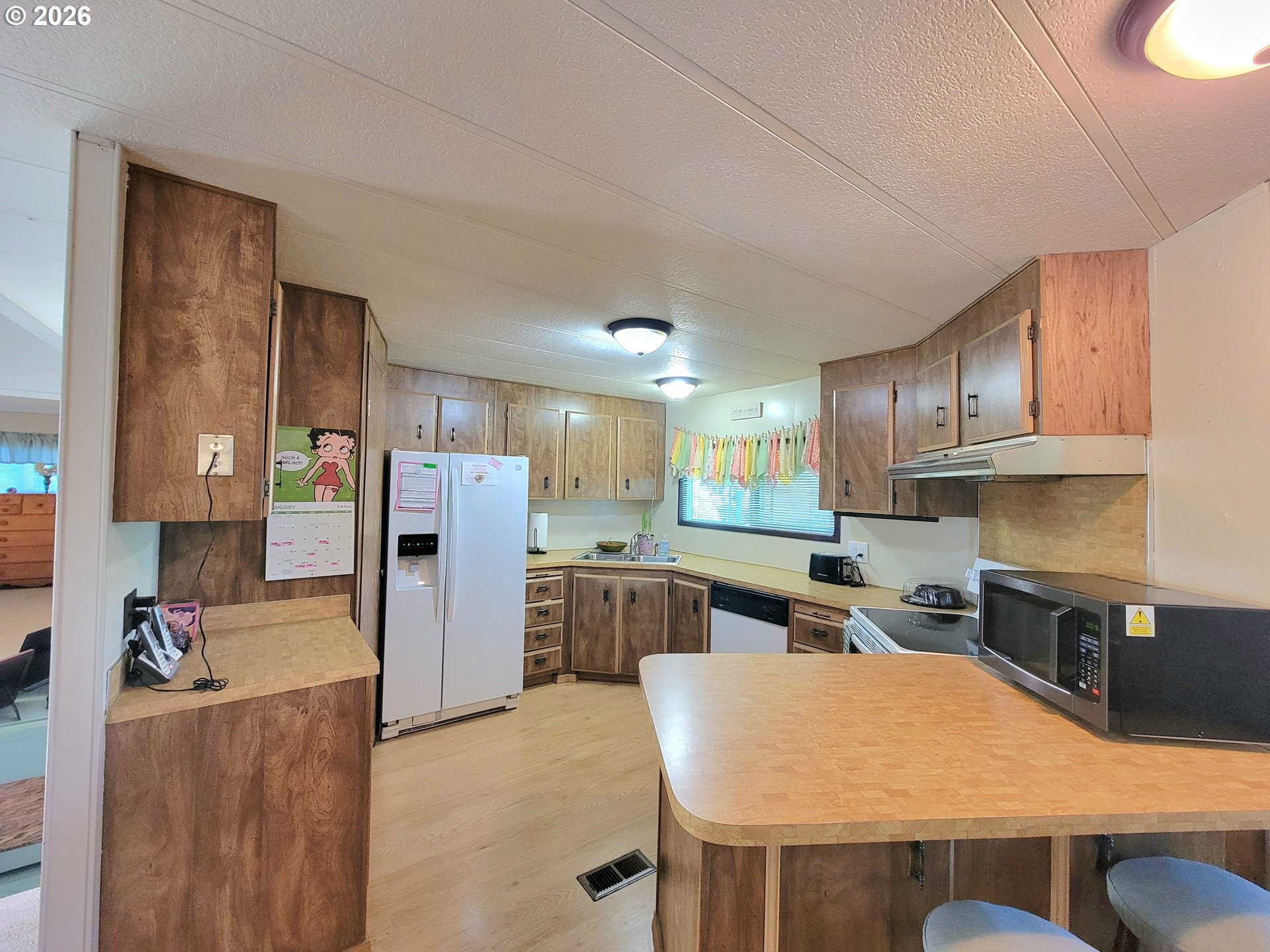 1199 North Terry Street, Unit 309 Eugene, OR 97402 - Photo 18 of 45 a kitchen with stainless steel appliances kitchen island granite countertop a refrigerator a stove top oven a sink and dishwasher