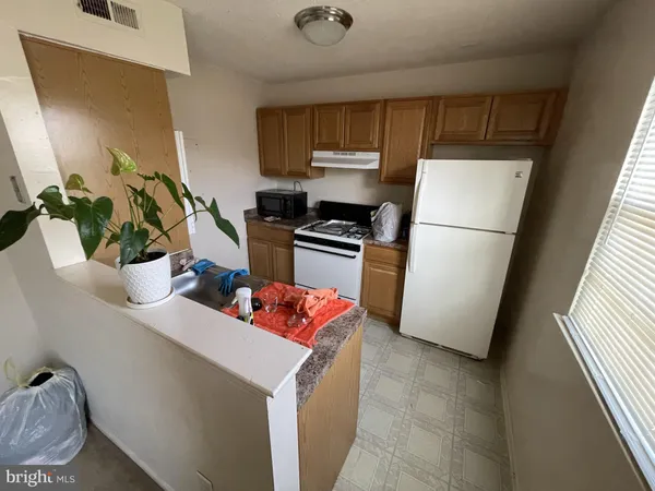 a kitchen with stainless steel appliances a refrigerator a sink a stove a microwave a sink and cabinets