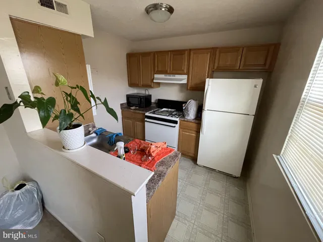 a kitchen with stainless steel appliances a refrigerator a sink a stove a microwave a sink and cabinets