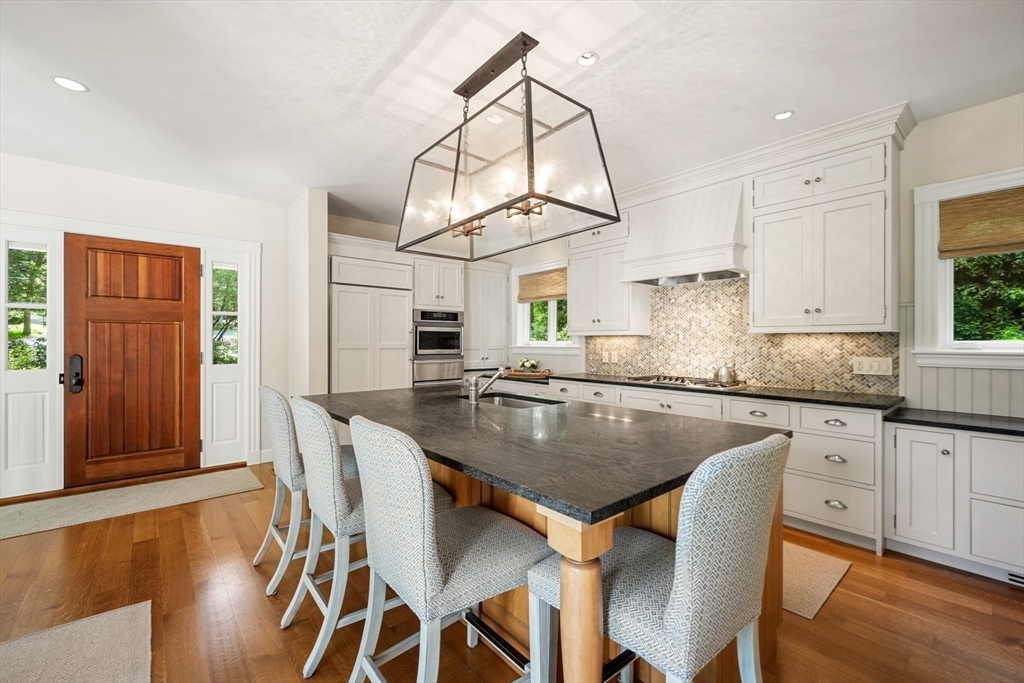 70 Old Farm Road Wellesley, MA 02481 - Photo 5 of 38 a kitchen with granite countertop a table chairs stove and cabinets