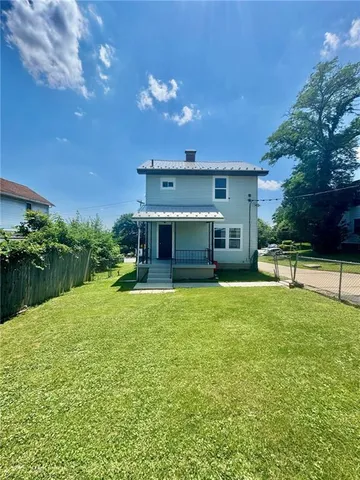 a front view of a house with a yard and trees