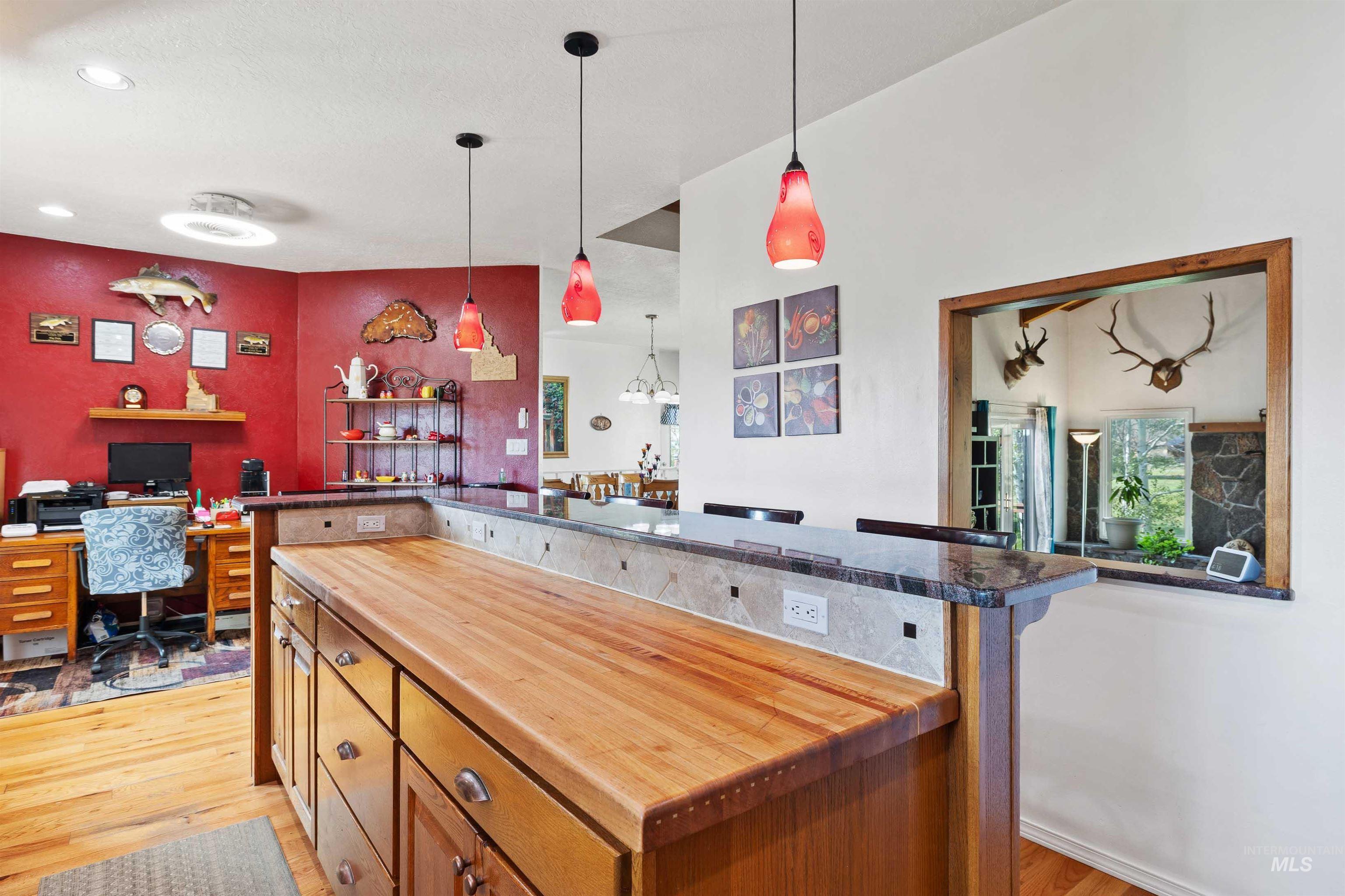 216 Ranch View Road West Jerome, ID 83338 - Photo 11 of 42 Kitchen island with butcher block countertop, granite breakfast bar, and pendant lighting
