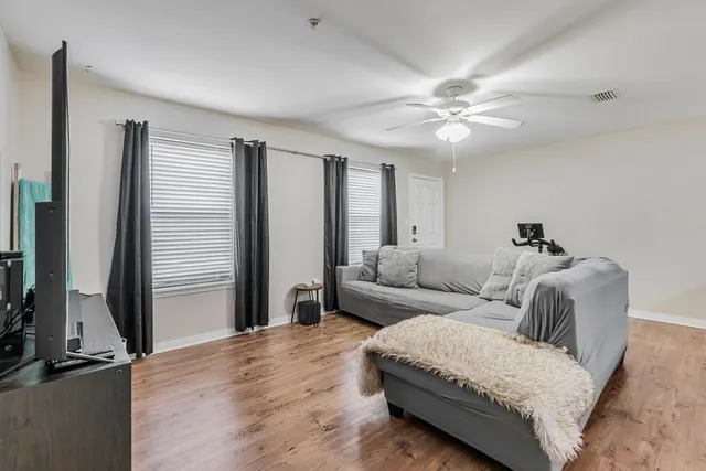 a living room with furniture and a ceiling fan