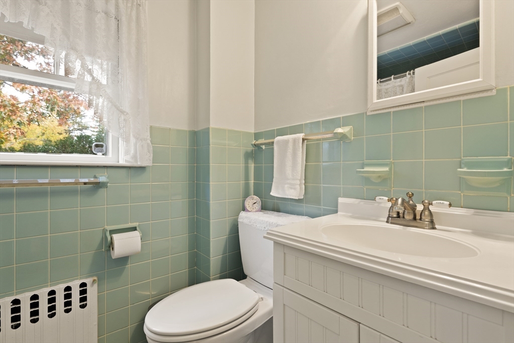 103 Madison Street Dedham, MA 02026 - Photo 16 of 21 a bathroom with a sink a toilet and shower curtain