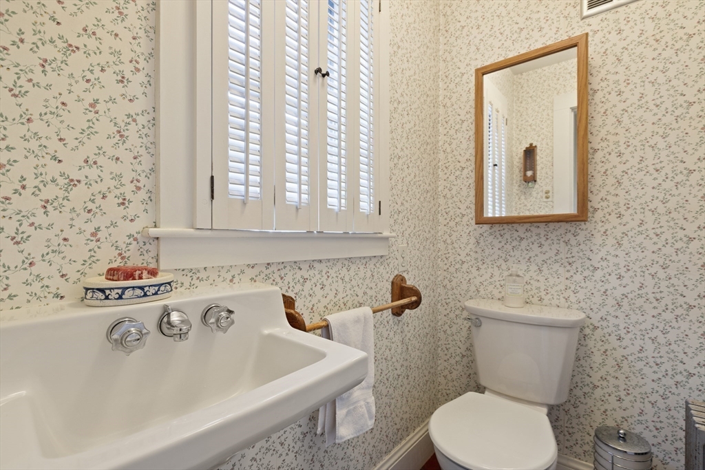 103 Madison Street Dedham, MA 02026 - Photo 17 of 21 a bathroom with a toilet sink and mirror