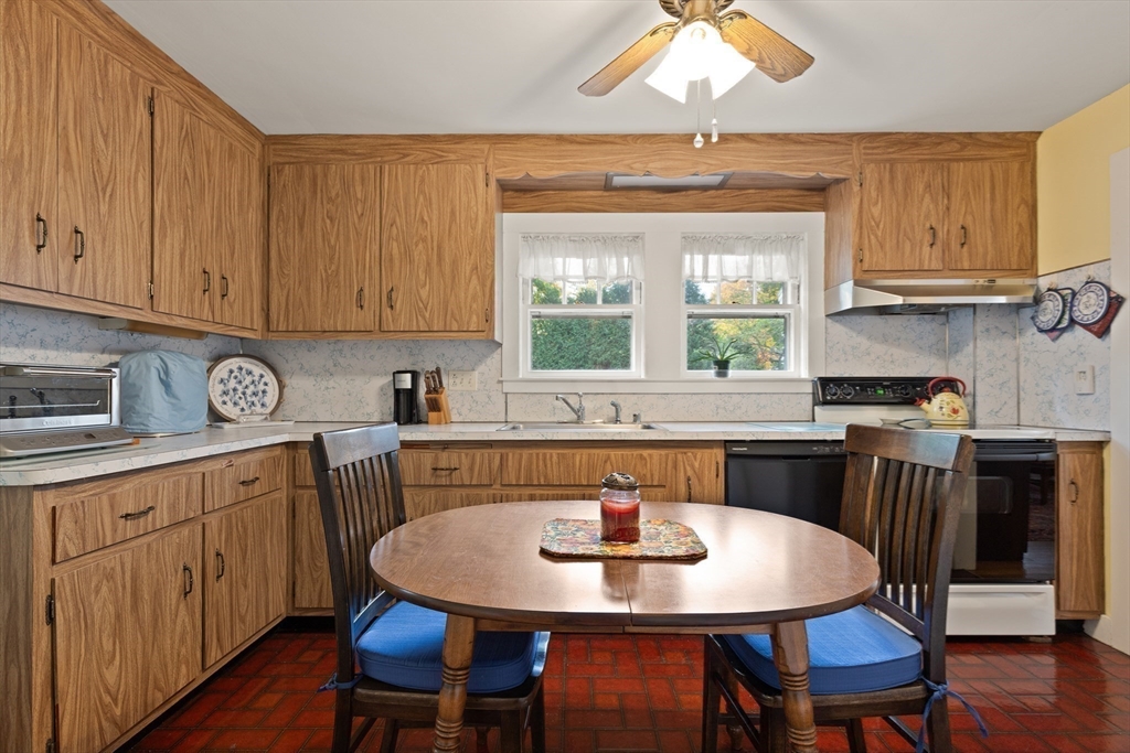 103 Madison Street Dedham, MA 02026 - Photo 8 of 21 a kitchen with granite countertop a dining table chairs and white cabinets