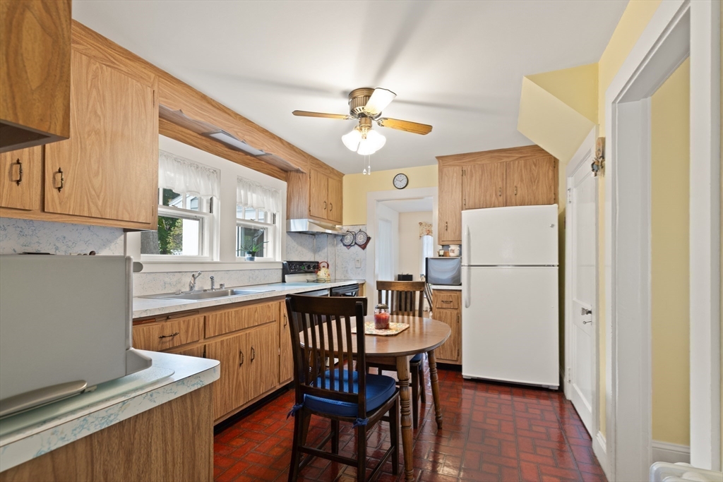 103 Madison Street Dedham, MA 02026 - Photo 9 of 21 a kitchen with a table chairs refrigerator and cabinets