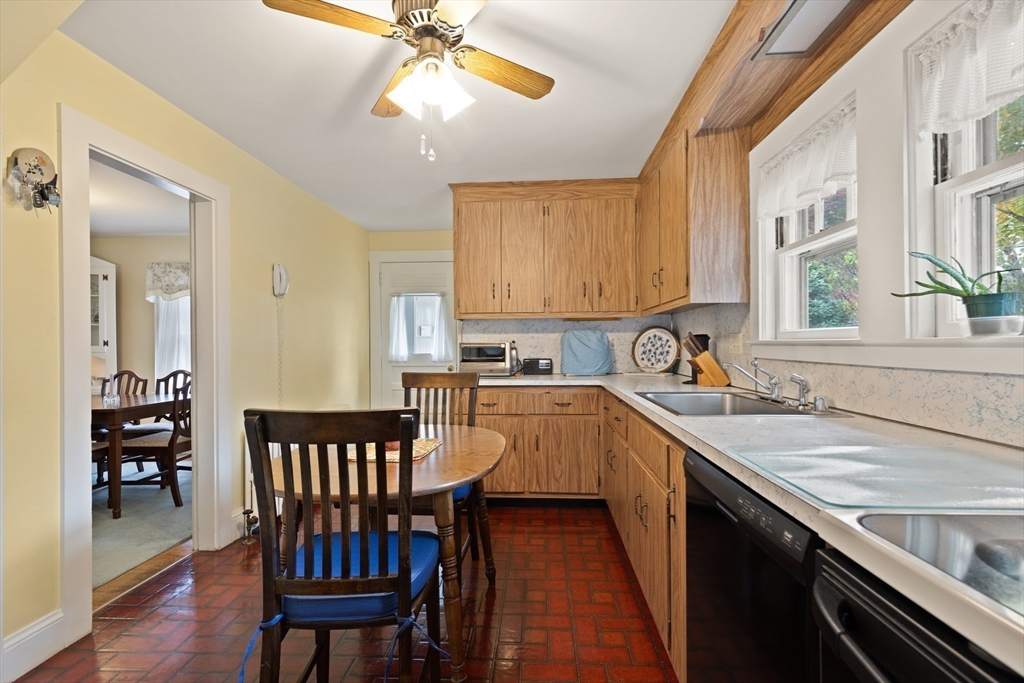 103 Madison Street Dedham, MA 02026 - Photo 10 of 21 a kitchen with stainless steel appliances granite countertop a sink dishwasher a stove a dining table and chairs with wooden floor