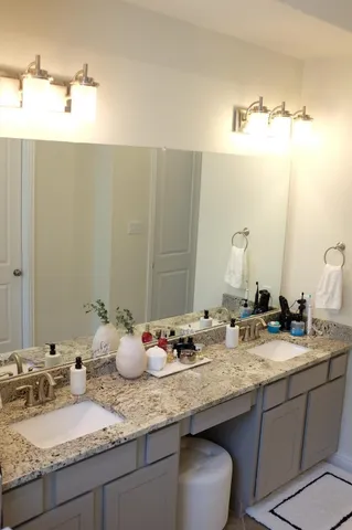 a bathroom with a granite countertop sink and a mirror