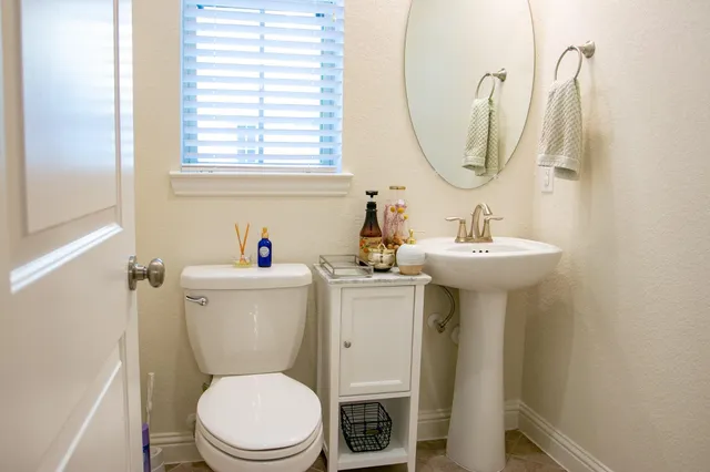 a white toilet sitting next to a bathroom sink