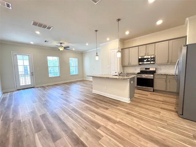 a view of a kitchen with a refrigerator and a stove top oven