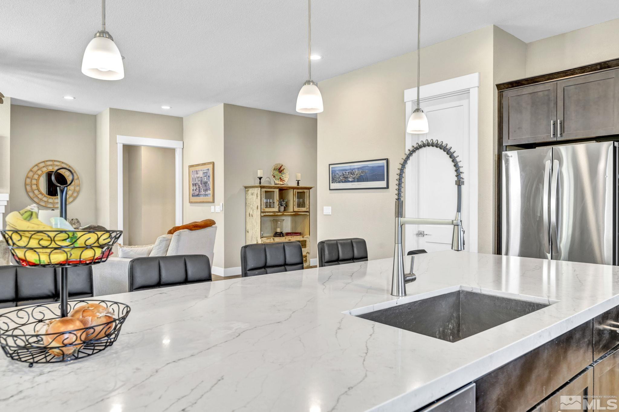 615 Sage Grouse Loop Stateline, NV 89449 - Photo 8 of 40 a kitchen with stainless steel appliances a sink a counter space and living room view