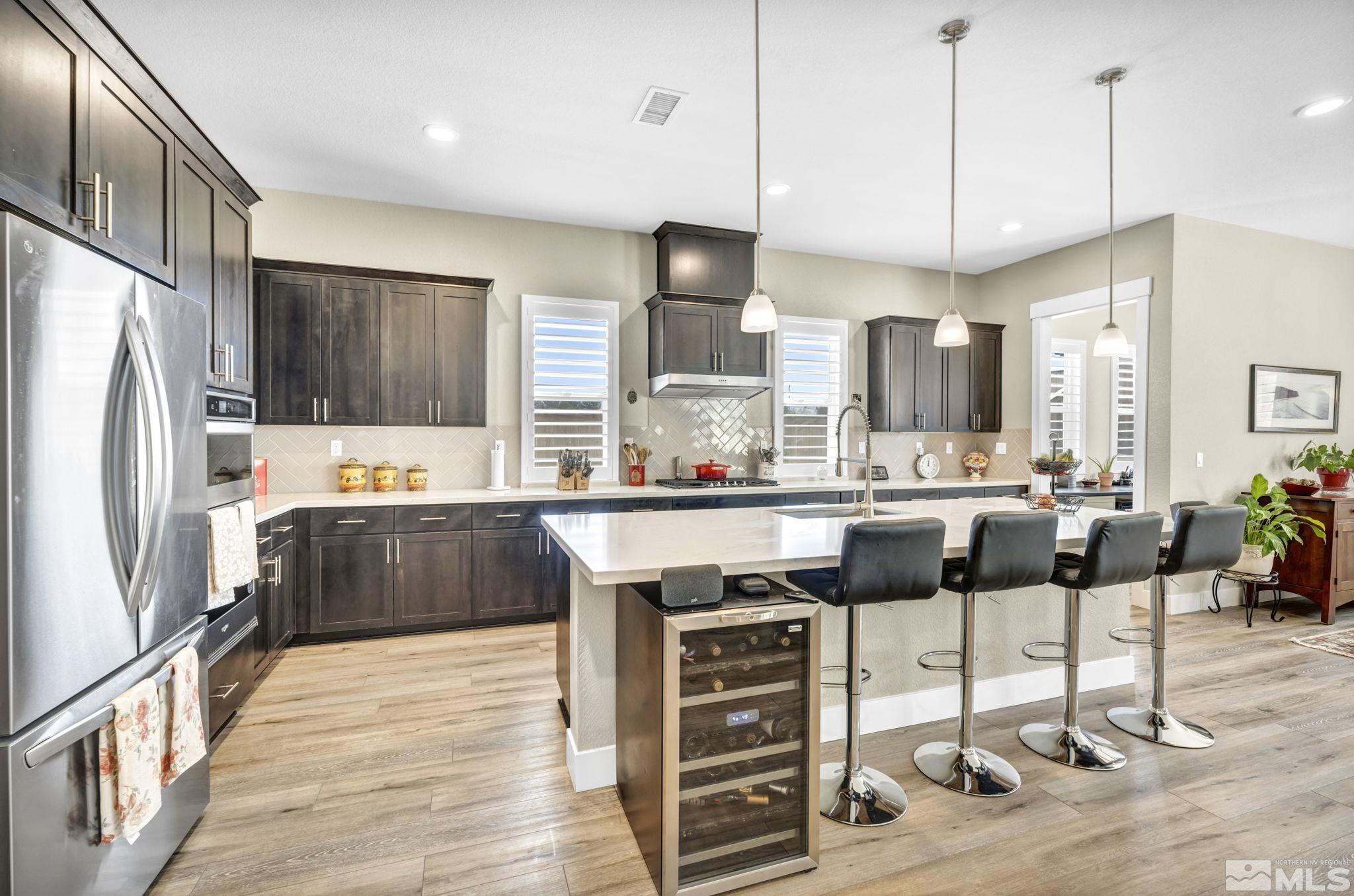 615 Sage Grouse Loop Stateline, NV 89449 - Photo 9 of 40 a kitchen with stainless steel appliances kitchen island granite countertop a refrigerator and a stove top oven