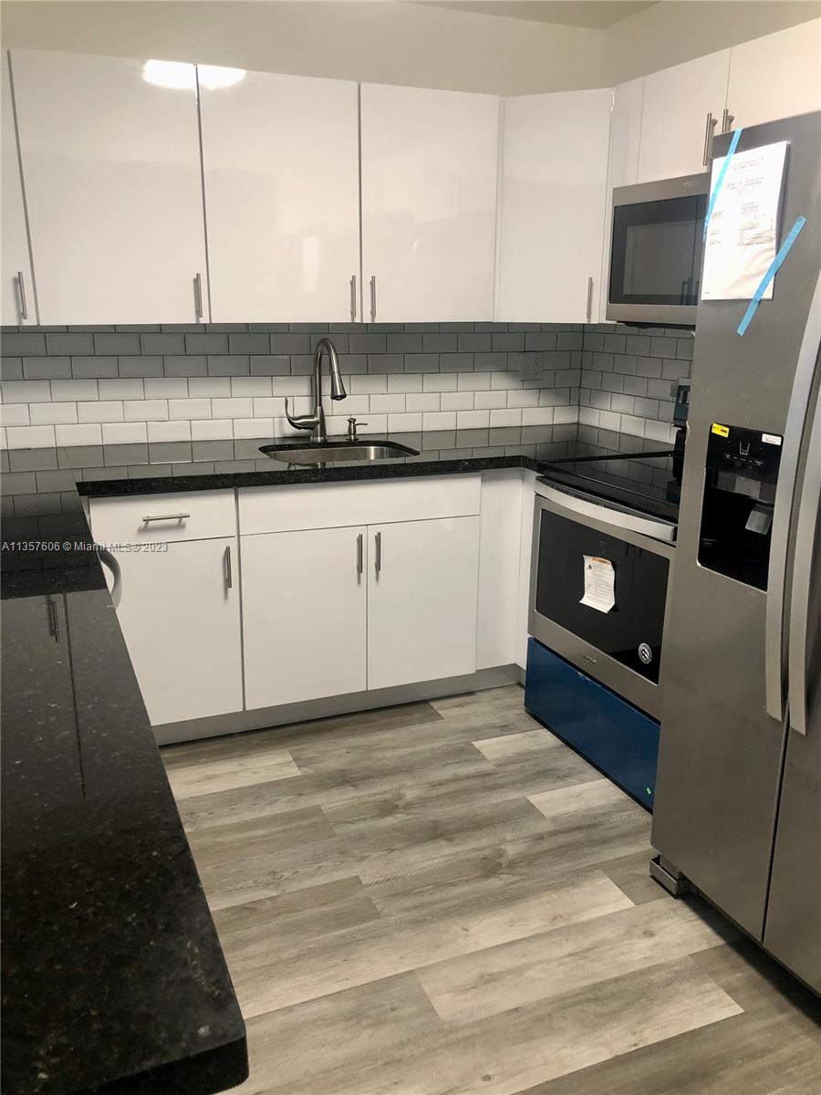 Hialeah Hialeah, FL 33012 - Photo 4 of 7 a kitchen with stainless steel appliances kitchen island granite countertop a sink stove and cabinets