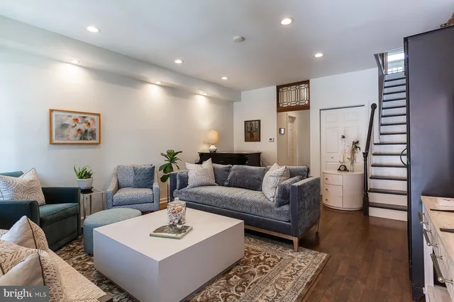 a dining room with furniture potted plants and wooden floor
