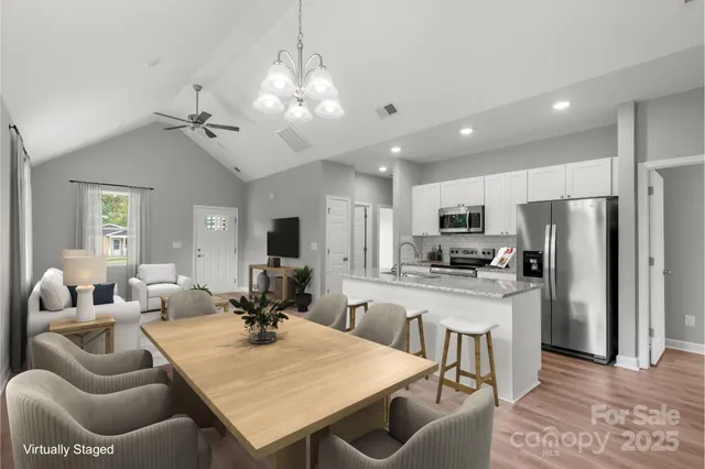 a large kitchen with kitchen island a large counter top appliances and cabinets