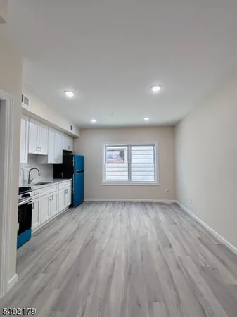 a view of kitchen with wooden floor and electronic appliances