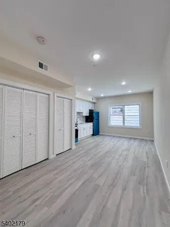 a view of empty room with wooden floor and window