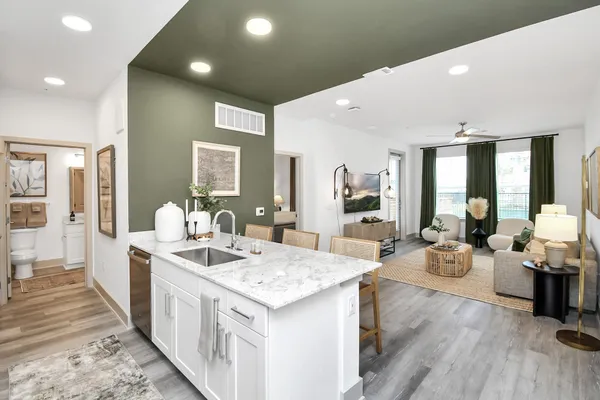 a large white kitchen with sink stove and wooden floor
