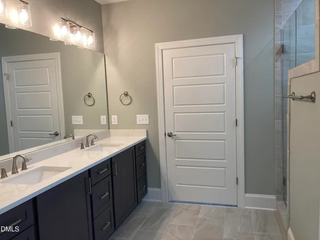 a bathroom with a double vanity sink and mirror