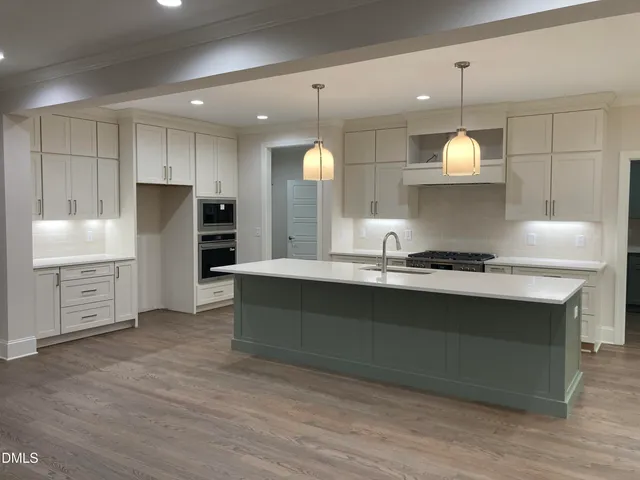 a kitchen with stainless steel appliances granite countertop a sink a stove and a refrigerator