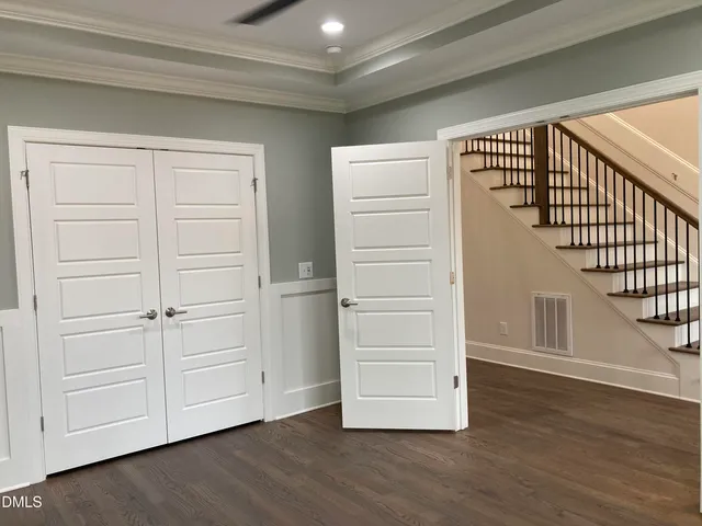 a view of a hallway with wooden floors and entryway