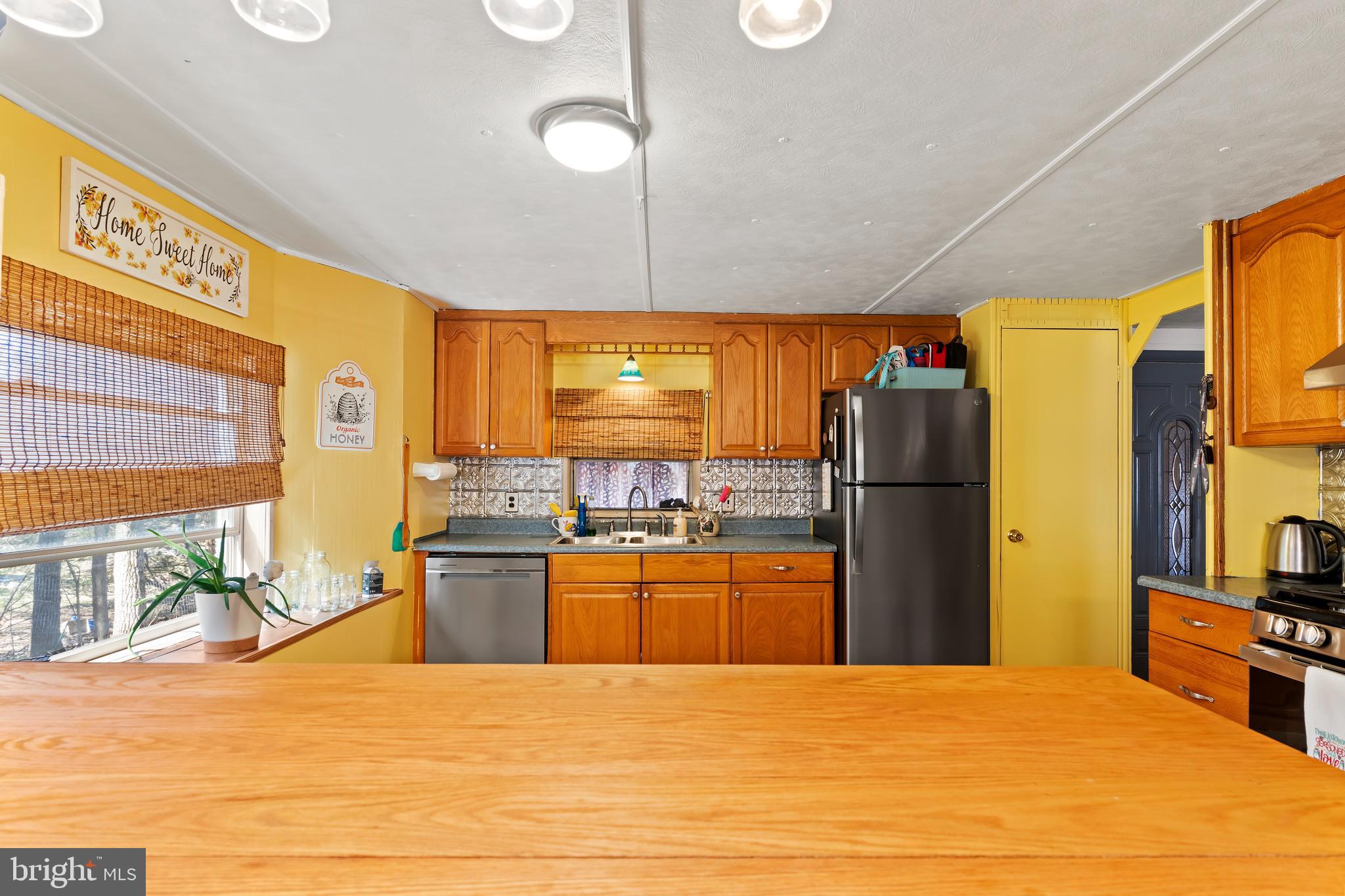 295 Greenbriar Road Elliottsburg, PA 17024 - Photo 2 of 25 a kitchen with stainless steel appliances kitchen island granite countertop a refrigerator a stove top oven and a dining table with wooden floor