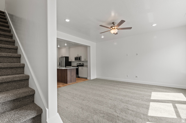 3410 South 1010th Street West Logan, UT 84321 - Photo 6 of 15 Unfurnished living room featuring stairs, light carpet, recessed lighting, and a ceiling fan