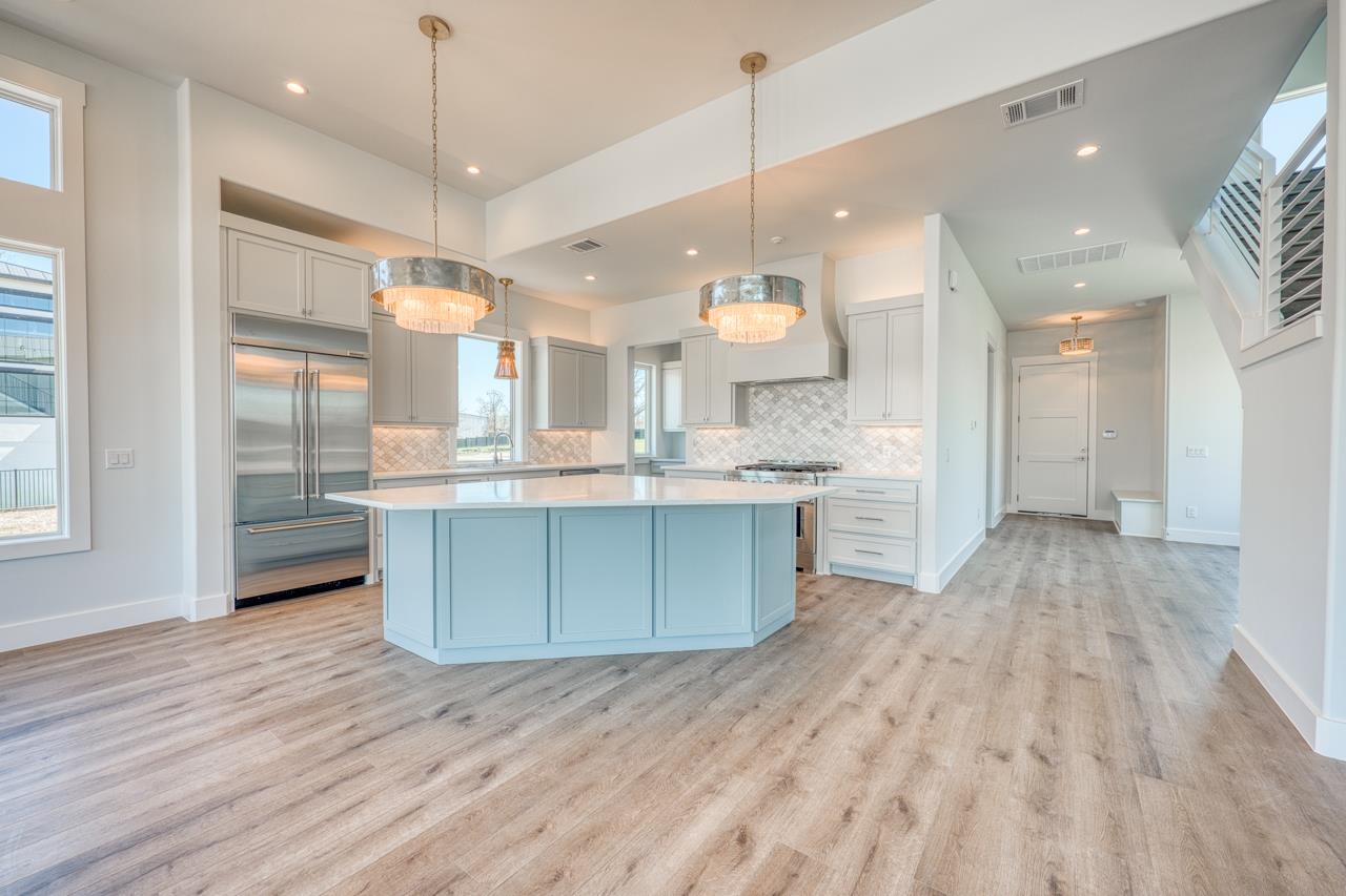 320 Lake Street Kingsland, TX 78639 - Photo 3 of 30 a large kitchen with stainless steel appliances kitchen island a large island in the center and wooden floors