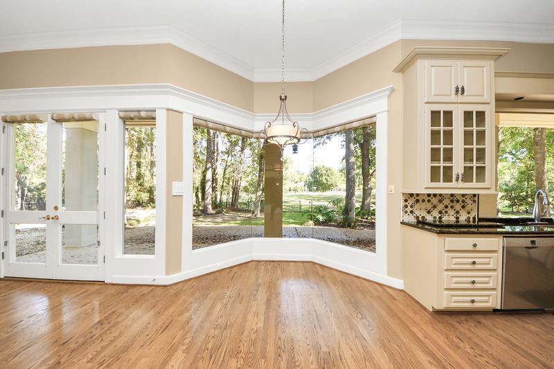 169 Grogans Point Road The Woodlands, TX 77380 - Photo 18 of 46 Check out this butted glass window in the breakfast room. This creates an expansive, unobstructed view. The custom roller blinds offer privacy when desired but bathe the home in natural light when open!