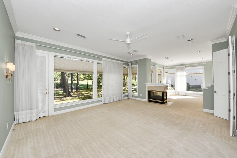 169 Grogans Point Road The Woodlands, TX 77380 - Photo 23 of 46 The view of the golf course is amazing! Notice the double-sided fireplace that separates the sleeping area from the bonus/sitting room of the primary suite. So romantic! This space has such flexibility; it can be used as a study or a workout room!