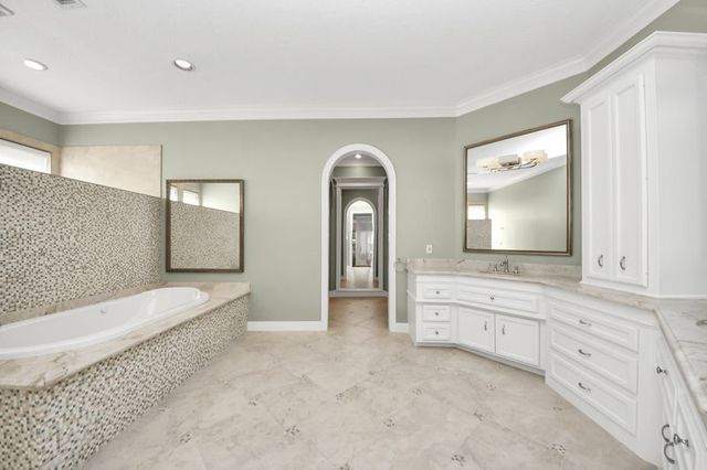 a spacious bathroom with a granite countertop sink mirror and bathtub