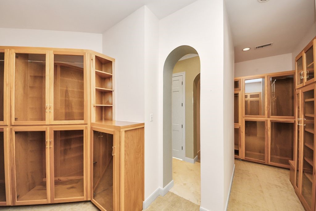 169 Grogans Point Road The Woodlands, TX 77380 - Photo 26 of 46 This custom "his & hers" closet is a dream! Glass doors keep dust off your clothes but offer an easy view of your wardrobe.